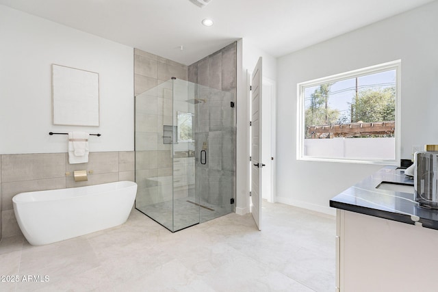 707 E Ocotillo Rd, Phoenix, AZ 85014 - full bathroom with a stall shower, a freestanding bath, vanity, recessed lighting, and baseboards