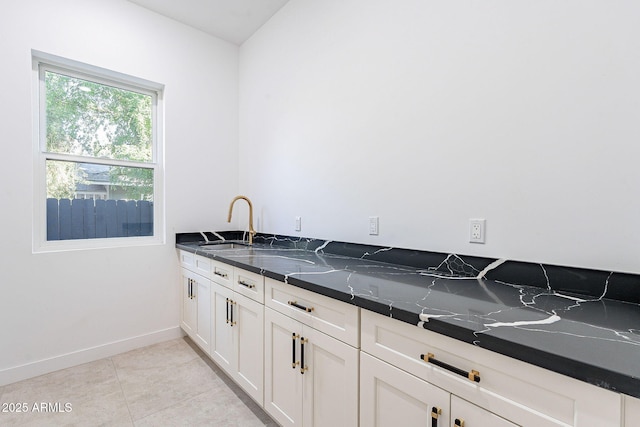 707 E Ocotillo Rd, Phoenix, AZ 85014 - kitchen with baseboards, white cabinetry, light tile patterned floors, and a sink