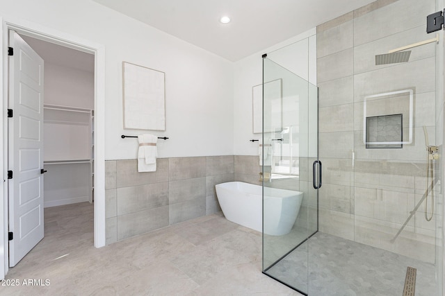 707 E Ocotillo Rd, Phoenix, AZ 85014 - bathroom featuring tile walls, a soaking tub, a shower stall, a walk in closet, and recessed lighting