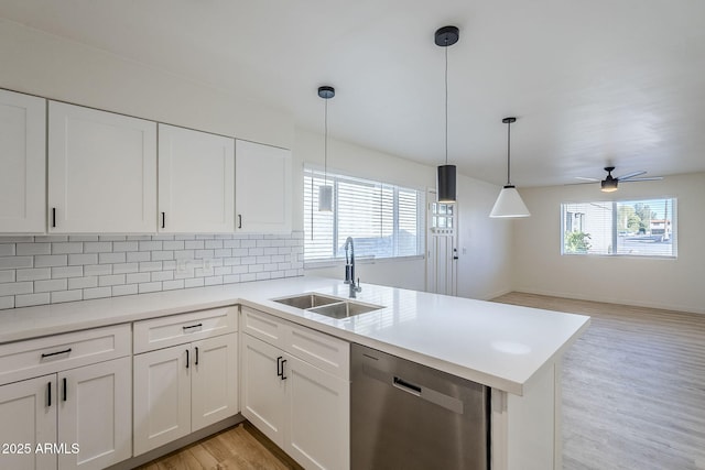 kitchen with pendant lighting, stainless steel dishwasher, sink, and white cabinets