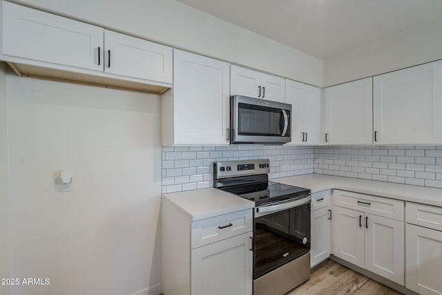 kitchen with white cabinetry, appliances with stainless steel finishes, and backsplash