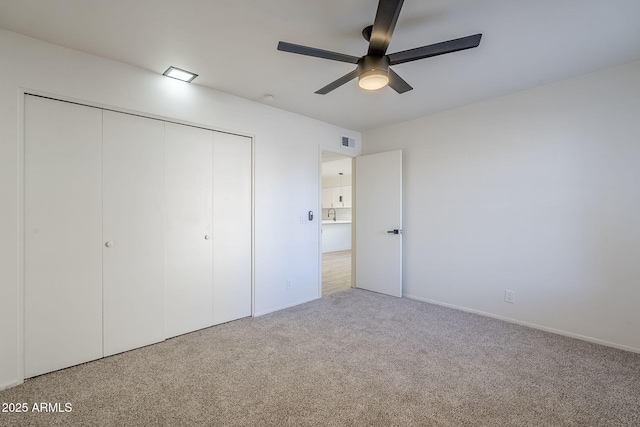 unfurnished bedroom with a closet, ceiling fan, and carpet