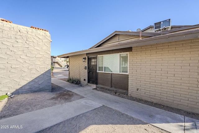 doorway to property with cooling unit and a patio area