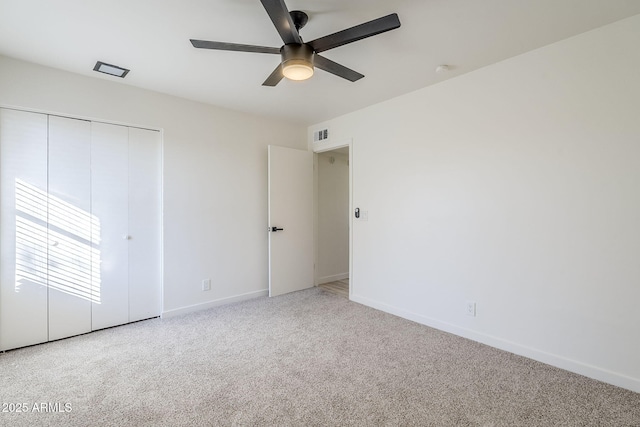 unfurnished bedroom with light colored carpet, ceiling fan, and a closet