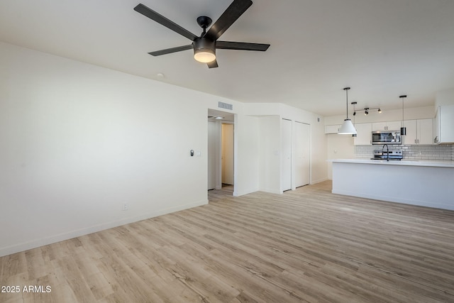 unfurnished living room featuring ceiling fan and light hardwood / wood-style floors