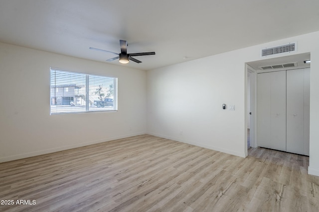 empty room with light hardwood / wood-style flooring and ceiling fan