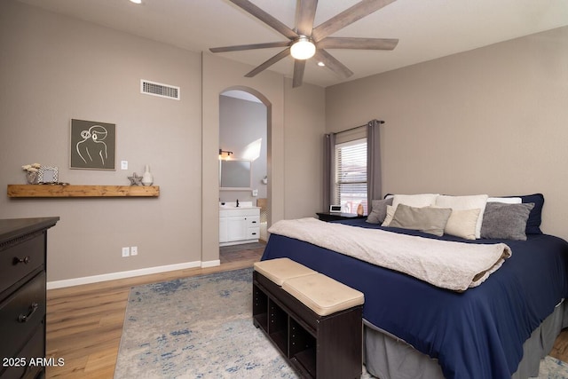 bedroom with hardwood / wood-style flooring, ceiling fan, and ensuite bath