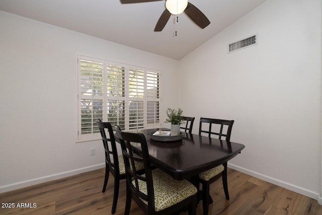 dining room featuring vaulted ceiling, dark hardwood / wood-style floors, and ceiling fan