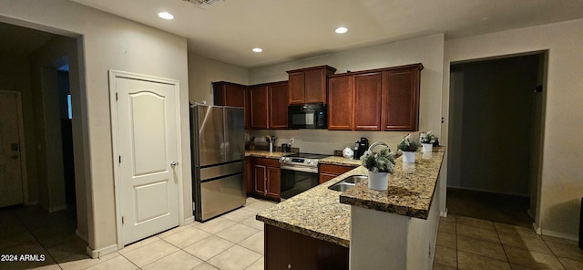 kitchen with light tile patterned floors, light stone countertops, kitchen peninsula, and appliances with stainless steel finishes