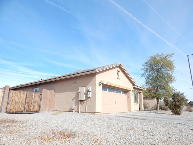 25422 W Maldonado Ct, Buckeye, AZ 85326 - view of side of home with an attached garage, stucco siding, and driveway
