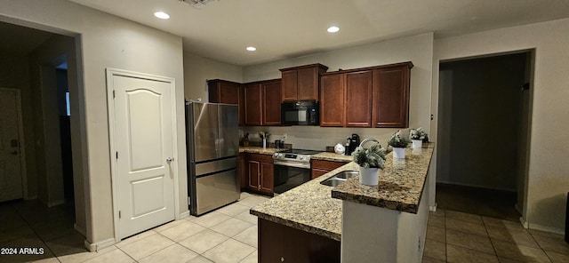 25422 W Maldonado Ct, Buckeye, AZ 85326 - kitchen featuring appliances with stainless steel finishes, a peninsula, light tile patterned floors, recessed lighting, and light stone countertops
