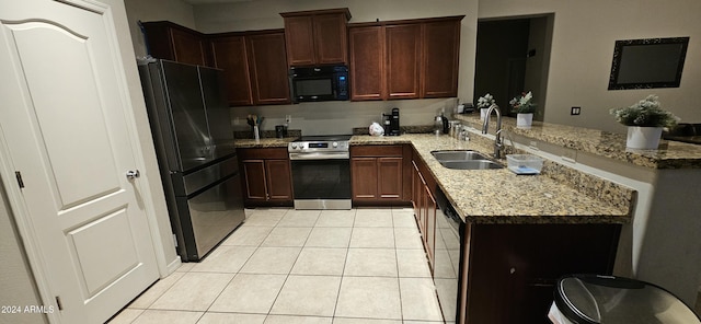 25422 W Maldonado Ct, Buckeye, AZ 85326 - kitchen featuring black appliances, a peninsula, light tile patterned floors, and light stone counters