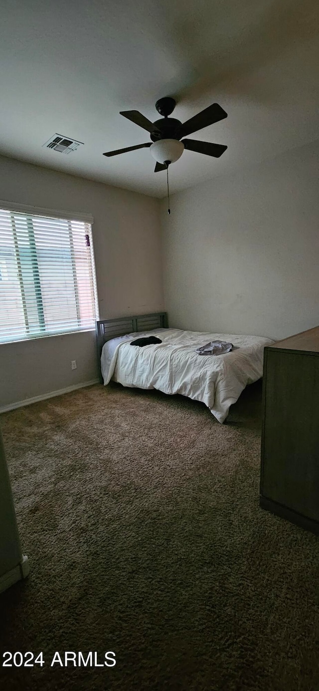 unfurnished bedroom featuring dark carpet and ceiling fan