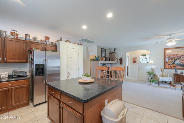 kitchen with ceiling fan, a center island, light colored carpet, and stainless steel refrigerator with ice dispenser