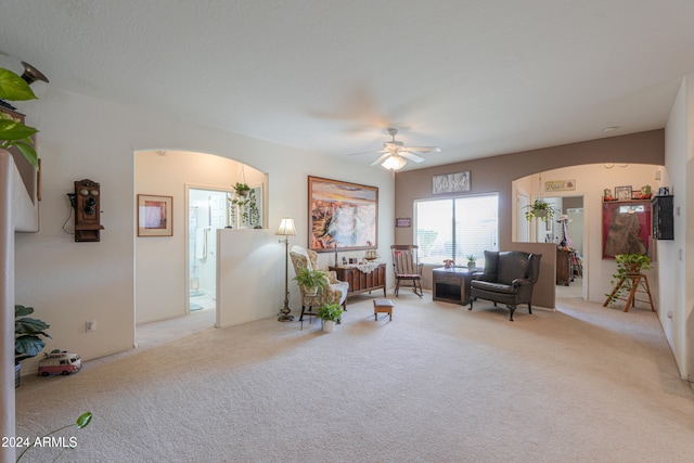 living area featuring ceiling fan and light carpet