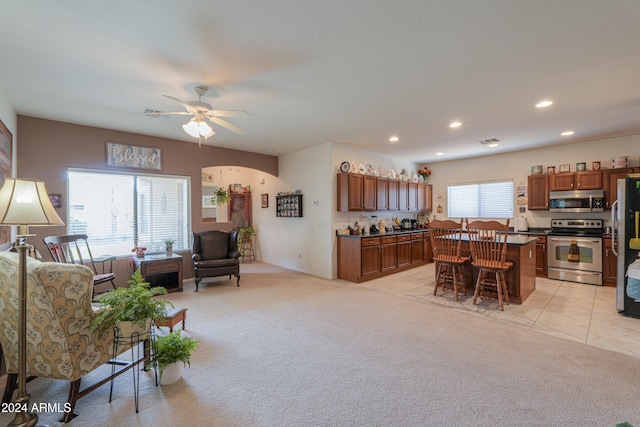 carpeted living room with ceiling fan