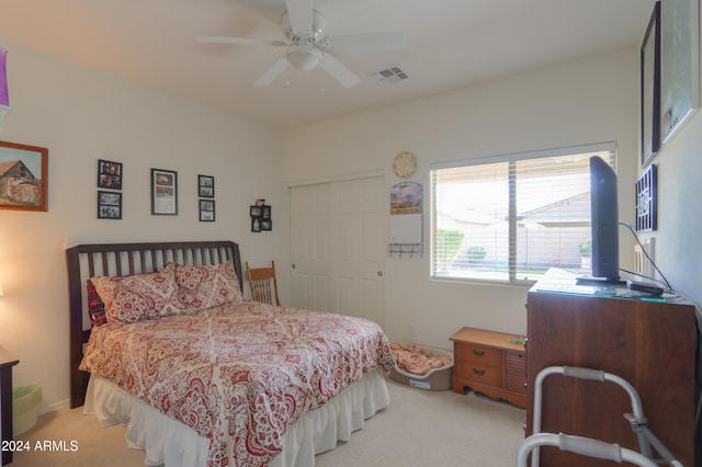 bedroom with light colored carpet, a closet, and ceiling fan