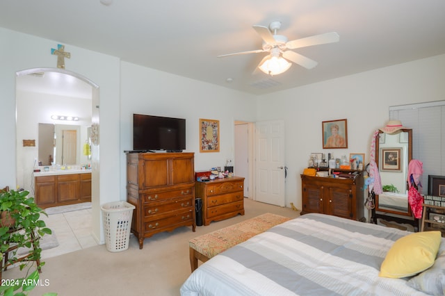 carpeted bedroom with ensuite bathroom and ceiling fan