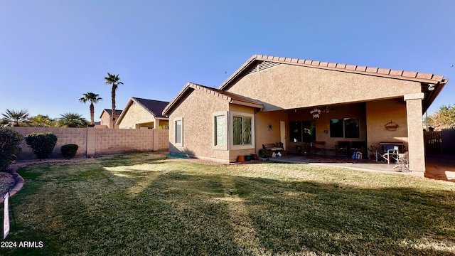 rear view of property featuring a lawn and a patio