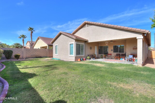 back of property featuring a lawn, ceiling fan, and a patio