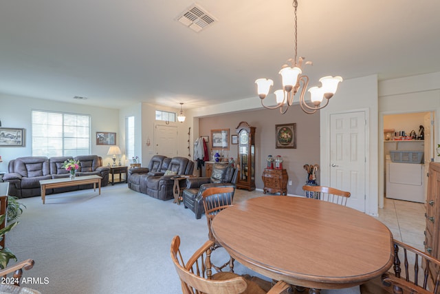 carpeted dining room with a notable chandelier and washer / clothes dryer