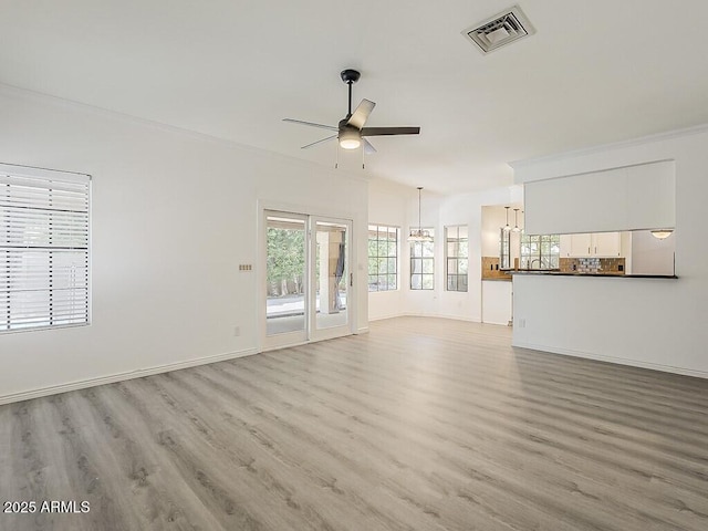 13064 N 100th Pl, Scottsdale, AZ 85260 - unfurnished living room featuring ceiling fan, light wood-style flooring, baseboards, and a chandelier