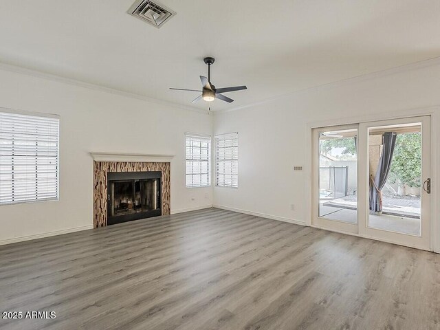 13064 N 100th Pl, Scottsdale, AZ 85260 - unfurnished living room with wood finished floors, ceiling fan, crown molding, plenty of natural light, and a fireplace