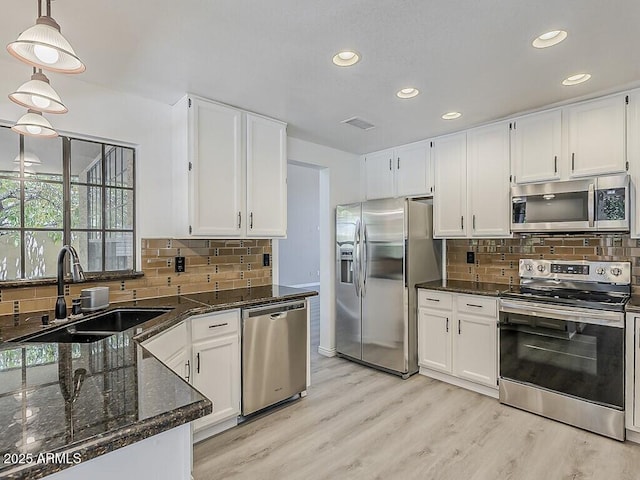 13064 N 100th Pl, Scottsdale, AZ 85260 - kitchen featuring stainless steel appliances, a sink, white cabinetry, recessed lighting, and dark stone countertops