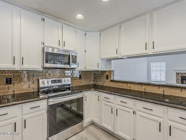 13064 N 100th Pl, Scottsdale, AZ 85260 - kitchen with appliances with stainless steel finishes, dark stone countertops, white cabinetry, and recessed lighting