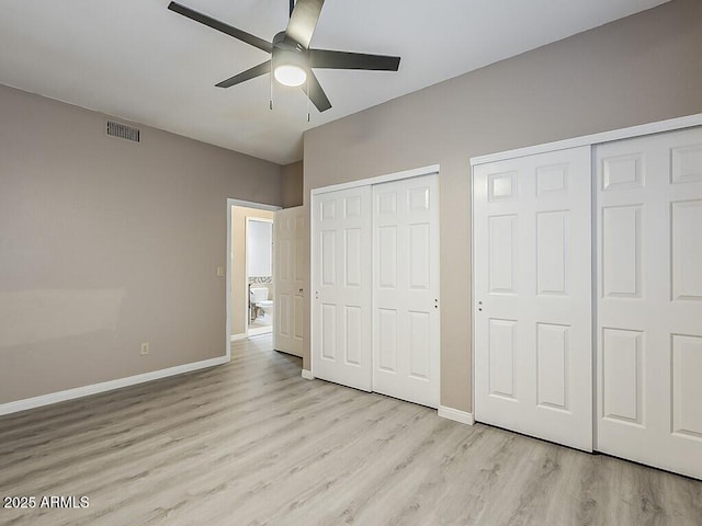 13064 N 100th Pl, Scottsdale, AZ 85260 - unfurnished bedroom featuring multiple closets, light wood-type flooring, baseboards, and ceiling fan
