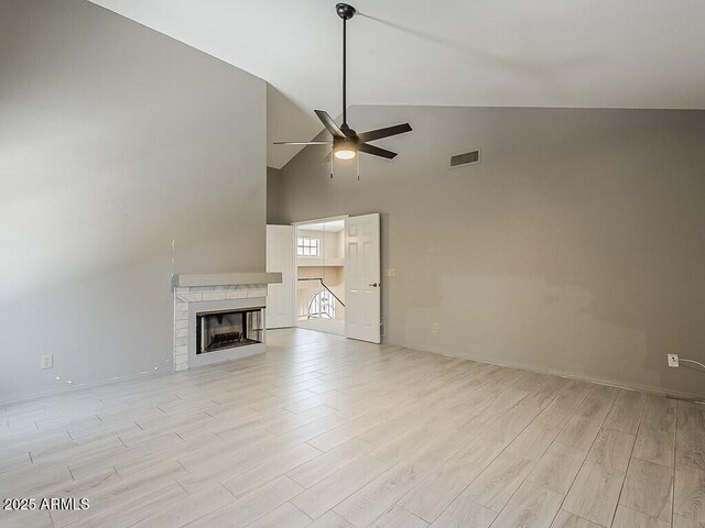 13064 N 100th Pl, Scottsdale, AZ 85260 - unfurnished living room featuring ceiling fan, light wood-style flooring, high vaulted ceiling, baseboards, and a fireplace