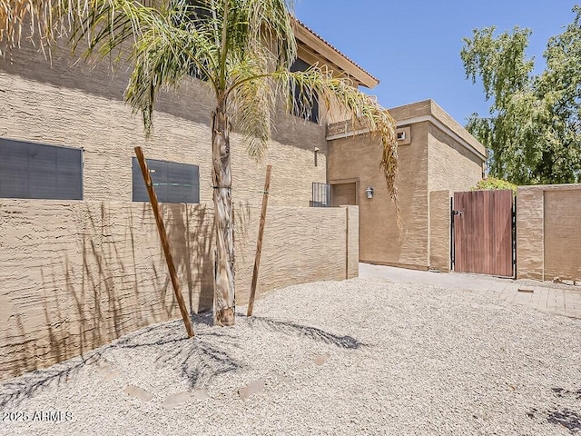 13064 N 100th Pl, Scottsdale, AZ 85260 - view of home's exterior with a gate and stucco siding