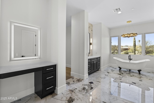 bathroom featuring vanity, a bathtub, and a notable chandelier