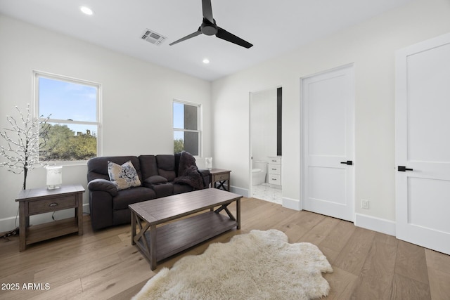 living room featuring light wood-type flooring and ceiling fan