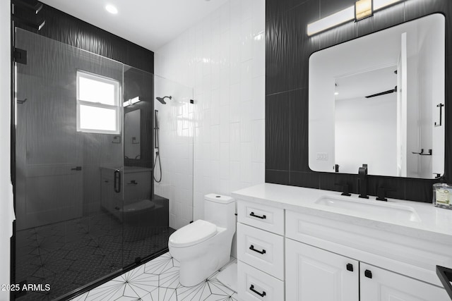 bathroom with toilet, tile patterned flooring, tile walls, walk in shower, and vanity