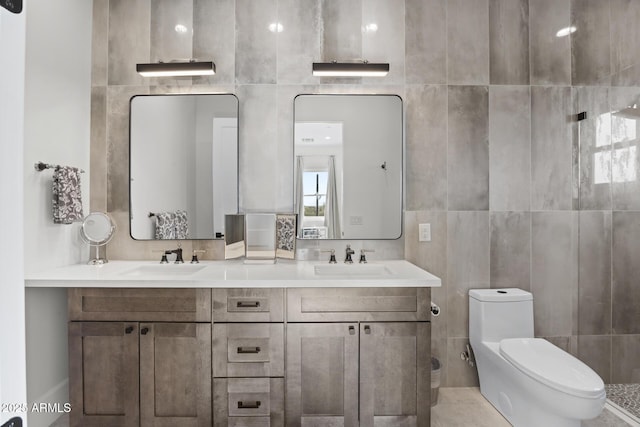 bathroom with toilet, vanity, and tile walls