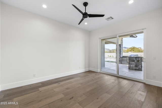 empty room with ceiling fan and hardwood / wood-style floors