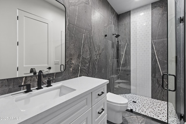 bathroom with an enclosed shower, vanity, decorative backsplash, tile walls, and toilet