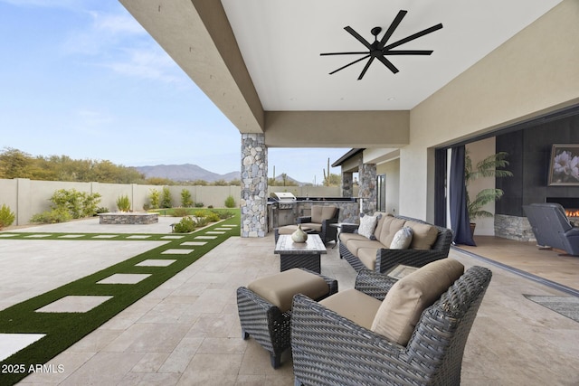 view of patio with a mountain view, ceiling fan, outdoor lounge area, and area for grilling