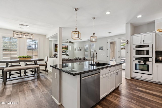20518 W White Rock Rd, Buckeye, AZ 85396 - kitchen with dishwasher, white double oven, plenty of natural light, dark wood finished floors, and recessed lighting