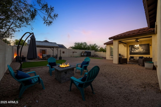 20518 W White Rock Rd, Buckeye, AZ 85396 - yard at dusk featuring an outdoor living space with a fire pit, a gazebo, a patio, and a fenced backyard