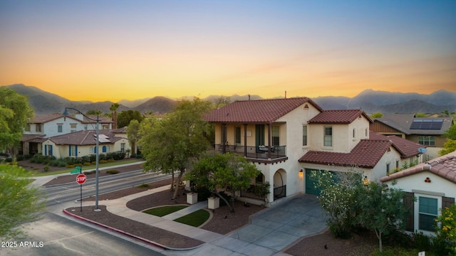 20518 W White Rock Rd, Buckeye, AZ 85396 - view of front of home with a balcony, a tile roof, a mountain view, stucco siding, and driveway