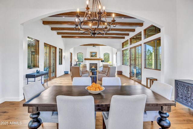 dining room with beam ceiling, french doors, and light wood-type flooring