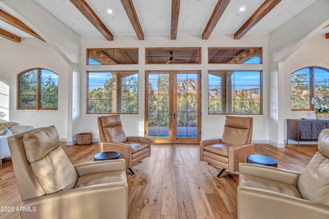 living room featuring french doors, beam ceiling, and light hardwood / wood-style flooring