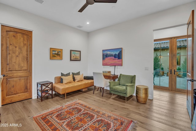 living area with ceiling fan, light wood-type flooring, and french doors