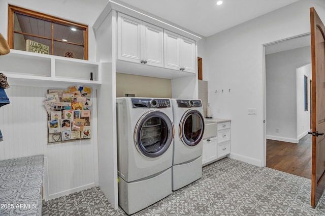 clothes washing area featuring cabinets and independent washer and dryer