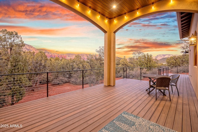 deck at dusk featuring a mountain view