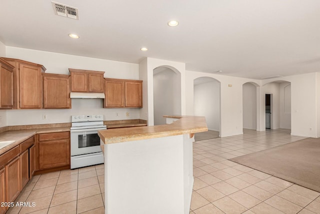 kitchen with light tile patterned floors, a kitchen island, and electric range