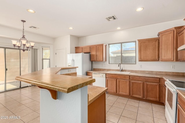 kitchen with sink, white appliances, light tile patterned floors, a kitchen island, and decorative light fixtures