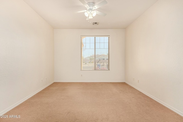 empty room featuring ceiling fan and light carpet